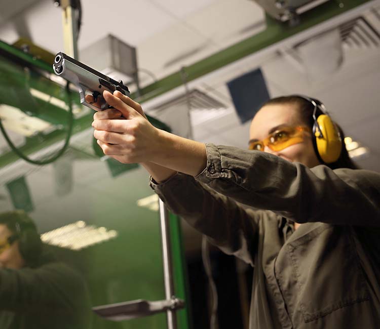 Female trainee aiming a handgun at a target during a training session at 3B Tactical in Miami, FL