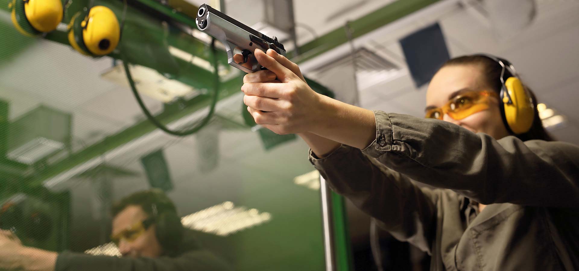 Female trainee aiming a handgun at a target during a training session at 3B Tactical in Miami, FL