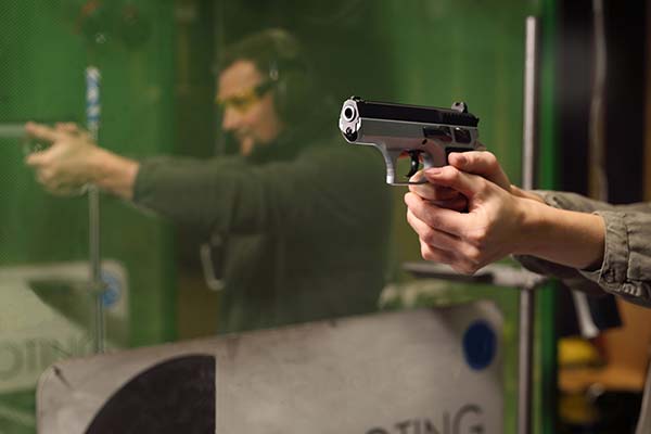 Close-up of a person holding a handgun at a shooting range at 3B Tactical in Miami, FL