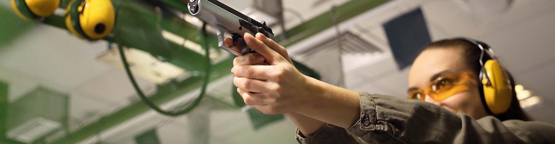 Woman practicing shooting techniques with a handgun at 3B Tactical's indoor range in Miami, FL