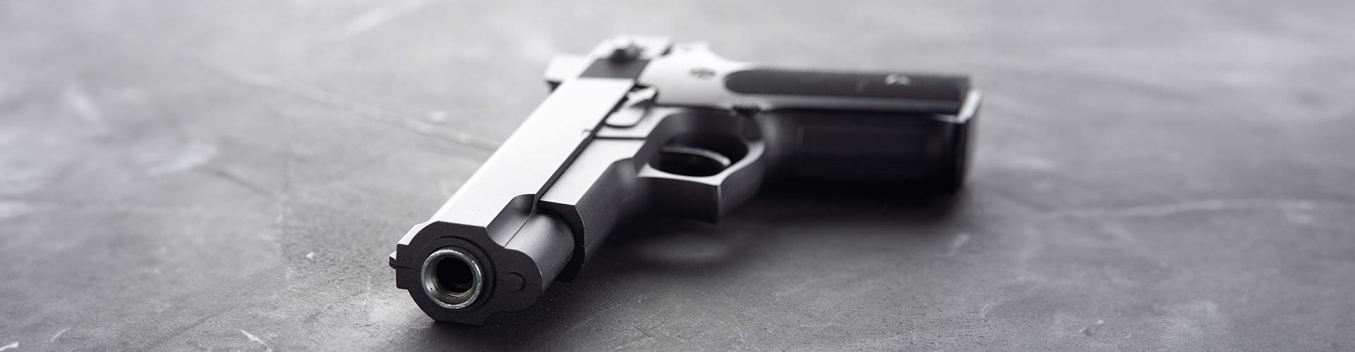 Black handgun resting on a gray surface at 3B Tactical in Miami, FL