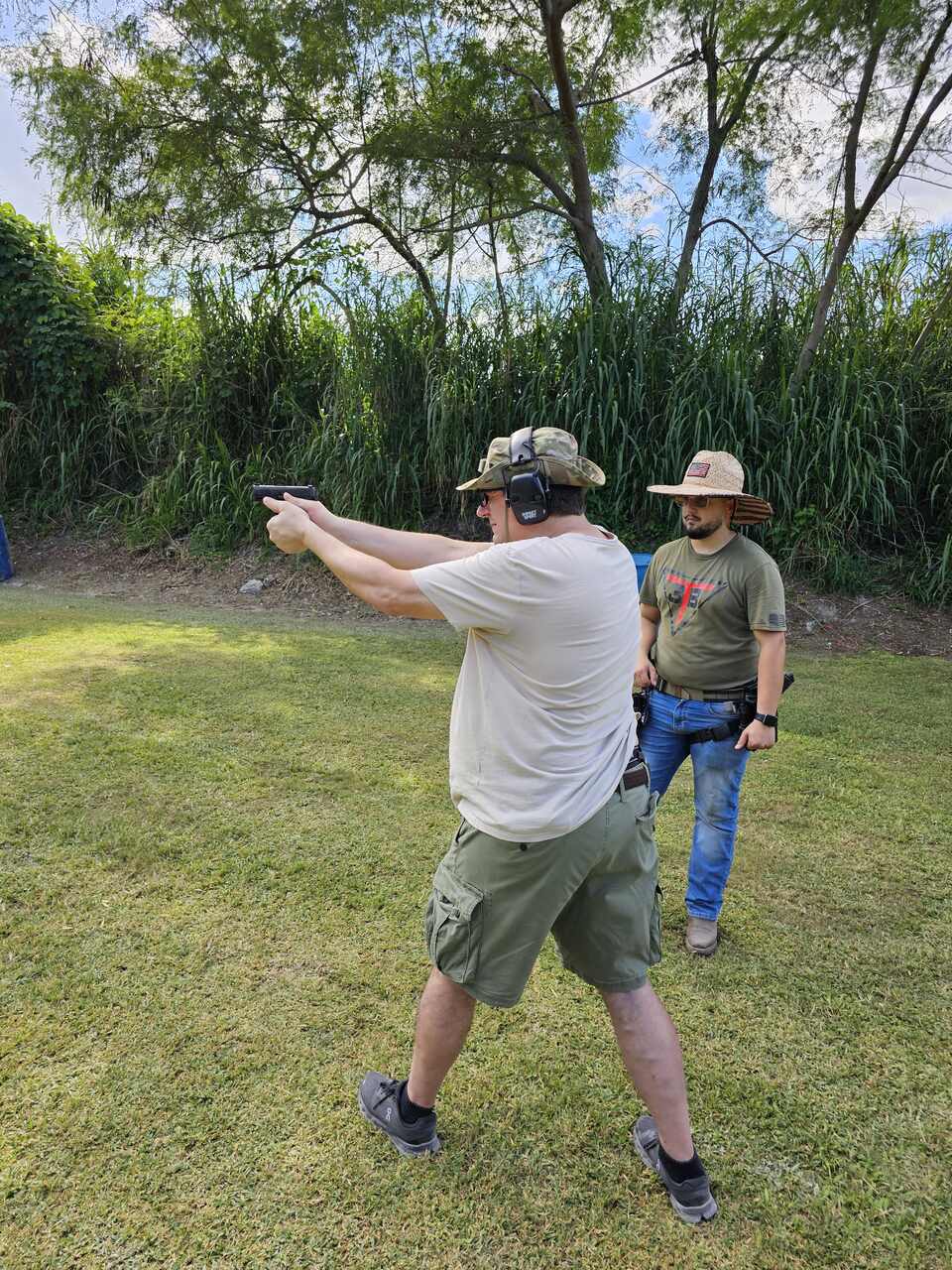 Instructor overseeing a trainee practicing handgun shooting at 3B Tactical in Miami, FL