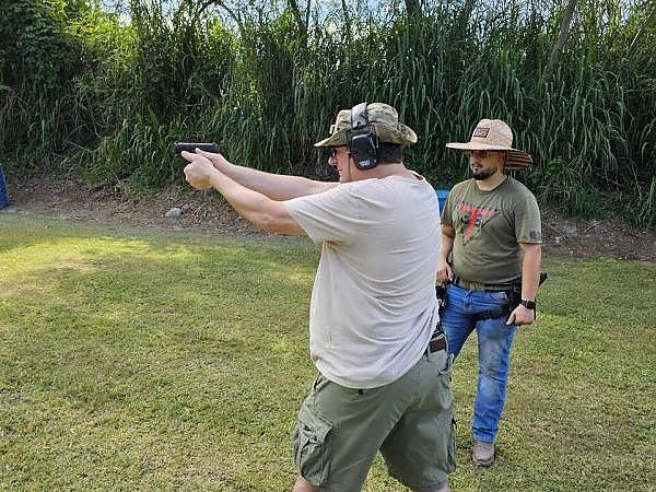 Instructor overseeing a trainee practicing handgun shooting at 3B Tactical in Miami, FL