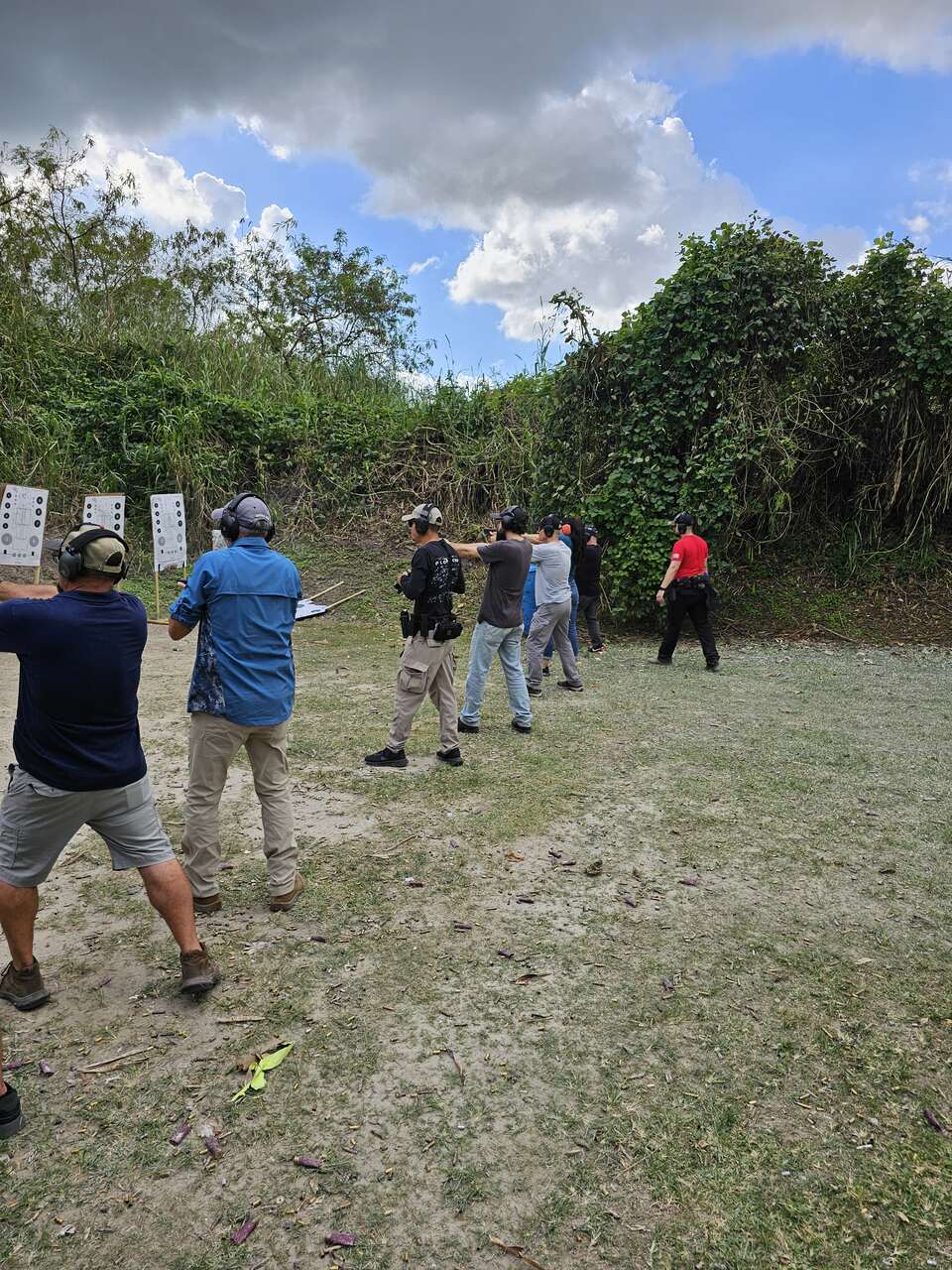 Trainees lined up and practicing shooting at targets during a training session at 3B Tactical in Miami, FL