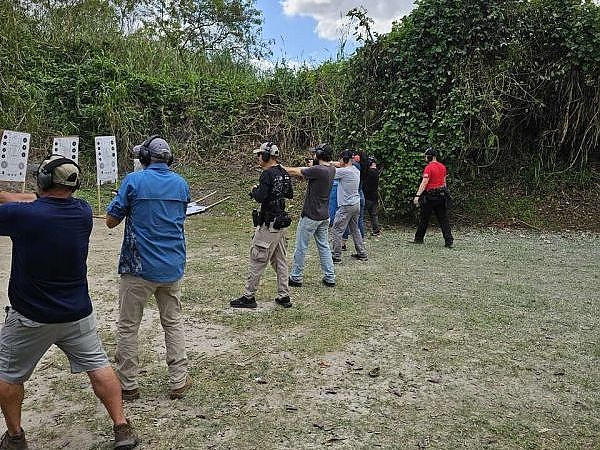 Trainees lined up and practicing shooting at targets during a training session at 3B Tactical in Miami, FL